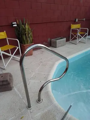 a metal rail around a swimming pool with chairs at Lago Azul in Embalse