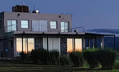 a house with a balcony on top of it at Puerto del Aguila potrero de Garay Inbalo 01 in Los Reartes
