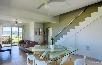 a dining room with a glass table and a staircase at Puerto del Aguila potrero de Garay Inbalo 01 in Los Reartes