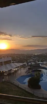 a view of a resort with two pools and a sunset at ERNESTINA VILLAGE Resort Apart & suites in Villa Carlos Paz
