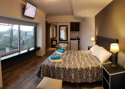 a hotel room with a bed and a large window at ERNESTINA VILLAGE Resort Apart & suites in Villa Carlos Paz