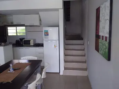 a kitchen with a white refrigerator and a staircase at ERNESTINA VILLAGE Resort Apart & suites in Villa Carlos Paz