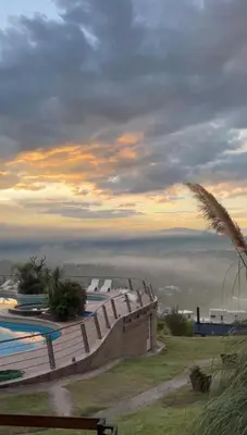 a view of a swimming pool with the ocean in the background at ERNESTINA VILLAGE Resort Apart & suites in Villa Carlos Paz