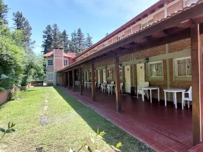 an outdoor patio with tables and chairs on a building at La Palapa ApartHotel in Villa General Belgrano