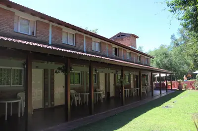 a building with tables and chairs outside of it at La Palapa ApartHotel in Villa General Belgrano