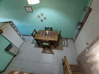 a kitchen with a wooden table and a refrigerator at La Palapa ApartHotel in Villa General Belgrano