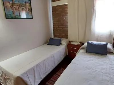 a room with two beds and a window at La Palapa ApartHotel in Villa General Belgrano