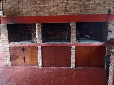 a brick fireplace with wooden doors on a brick wall at La Palapa ApartHotel in Villa General Belgrano