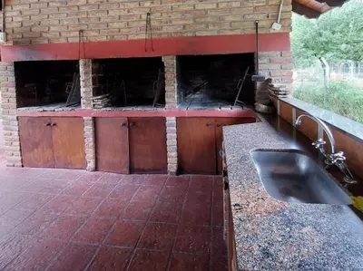 a kitchen with a sink and a brick wall at La Palapa ApartHotel in Villa General Belgrano