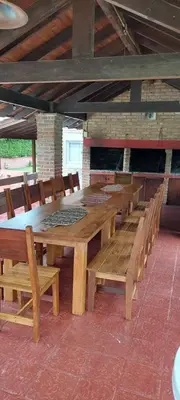 a large wooden table and chairs in a building at La Palapa ApartHotel in Villa General Belgrano