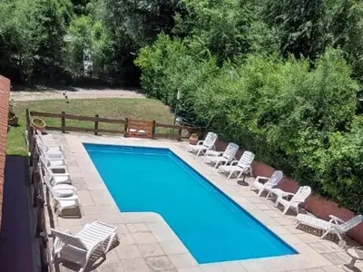 a swimming pool with lounge chairs and a swimming pool at La Palapa ApartHotel in Villa General Belgrano