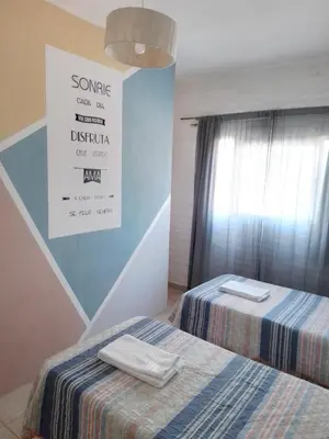 a bedroom with two beds and a sign on the wall at Duplex, Córdoba zona norte in Cordoba