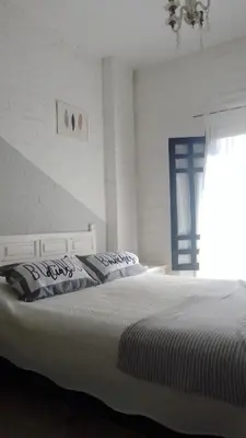 a white bedroom with two beds and a window at Duplex, Córdoba zona norte in Cordoba