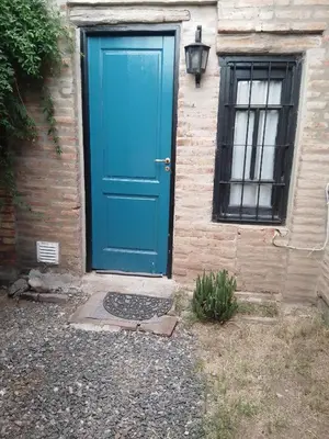 a blue door on a brick building with a window at Duplex, Córdoba zona norte in Cordoba