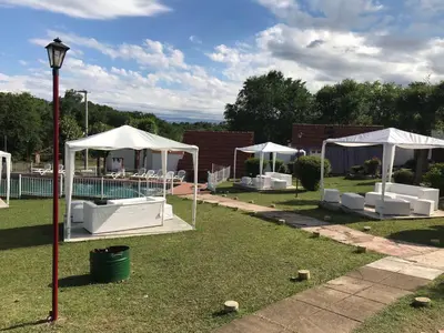 a group of white umbrellas and chairs in a yard at La Martinica in Villa Carlos Paz