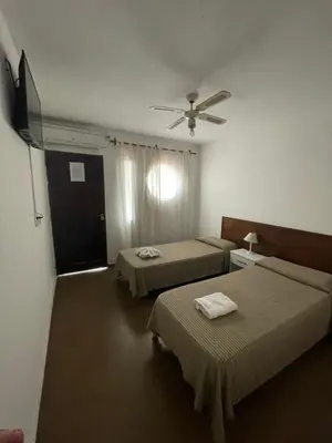 a hotel room with two beds and a television at La Martinica in Villa Carlos Paz