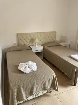 two beds in a hotel room with towels on them at La Martinica in Villa Carlos Paz