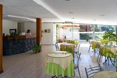 a restaurant with tables and chairs with a person in the background at La Martinica in Villa Carlos Paz