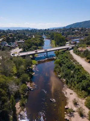 a bridge over a river with a train on it at La Martinica in Villa Carlos Paz