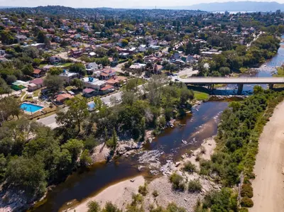 an aerial view of a town with a bridge over a river at La Martinica in Villa Carlos Paz
