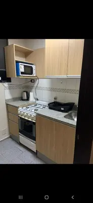 a small kitchen with a stove and a microwave at Alquiler Temporal en Nueva Córdoba! in Cordoba