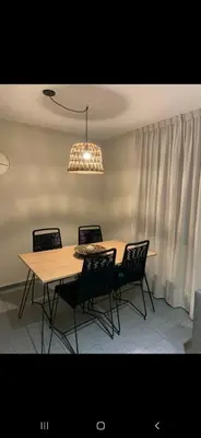 a dining room table with chairs and a chandelier at Alquiler Temporal en Nueva Córdoba! in Cordoba