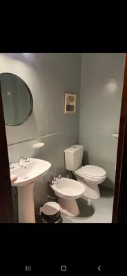 a bathroom with two sinks and a toilet and a mirror at Alquiler Temporal en Nueva Córdoba! in Cordoba