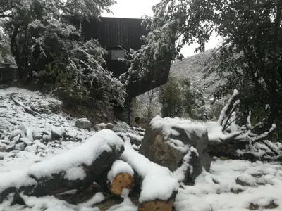 a snow covered yard with a building in the background at NIDO ARRIBA CABAÑAS in La Bolsa