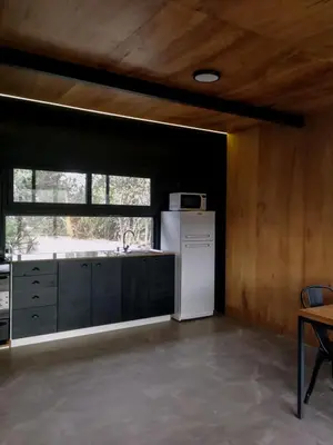 a kitchen with a white refrigerator and a window at NIDO ARRIBA CABAÑAS in La Bolsa