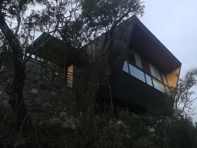 a house on top of a hill with trees at NIDO ARRIBA CABAÑAS in La Bolsa