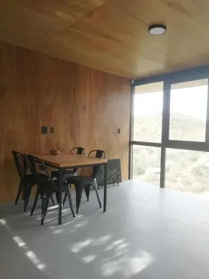 a dining room with a wooden table and chairs at NIDO ARRIBA CABAÑAS in La Bolsa