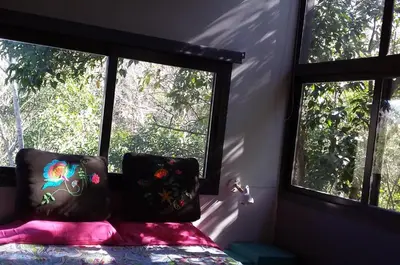 a bedroom with two windows and a bed with pink sheets at Torito's House 1 in Tanti