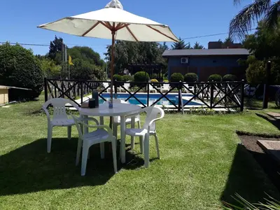 a white table and chairs under an umbrella at Cabañas Ruphay in Santa Rosa de Calamuchita