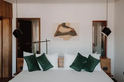 a bedroom with a white bed with green pillows at Böden Hotel & Spa, AKEN SOUL in Villa General Belgrano