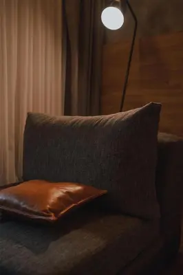 a brown pillow sitting on a couch with a lamp at Böden Hotel & Spa, AKEN SOUL in Villa General Belgrano