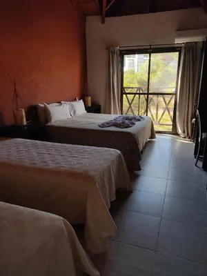 a hotel room with two beds and a window at Hotel posada barrancas del sol in Merlo