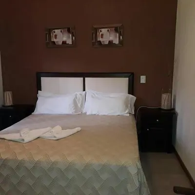 a bedroom with a bed with two towels on it at Hotel posada barrancas del sol in Merlo