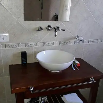 a white bowl sink on a wooden counter in a bathroom at Hotel posada barrancas del sol in Merlo