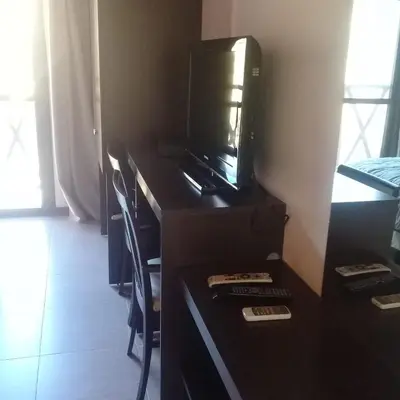 a room with a desk with a tv and a microwave at Hotel posada barrancas del sol in Merlo