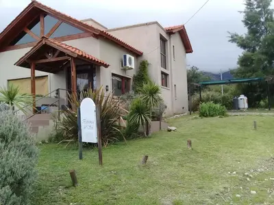 a house with a sign in front of it at Hotel posada barrancas del sol in Merlo
