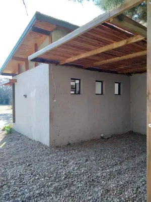a building with windows and a wooden roof at Cabañas Tierra Kamiare 2 in Villa Amancay