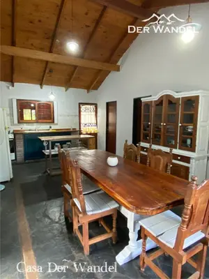 a dining room with a wooden table and chairs at Der Wandel in Villa General Belgrano