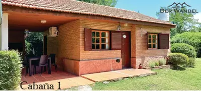 a small wooden house with a table and a chair at Der Wandel in Villa General Belgrano