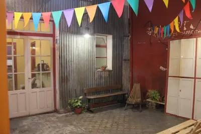 a patio with a bench and flags in a building at CASA ARTIGAS Hostel in Cordoba