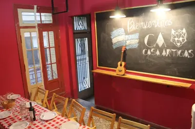 a restaurant with a chalkboard with a guitar on the wall at CASA ARTIGAS Hostel in Cordoba