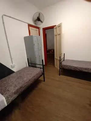a room with two beds and an open door at CASA ARTIGAS Hostel in Cordoba