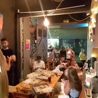 a group of people sitting at a table in a restaurant at CASA ARTIGAS Hostel in Cordoba