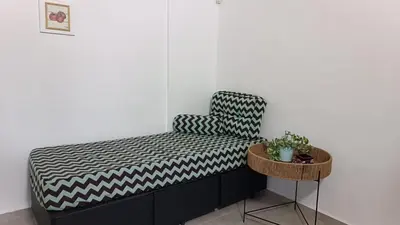 a bed in a room with a chair and a table at AA Departamento Flat Premium Córdoba in Cordoba