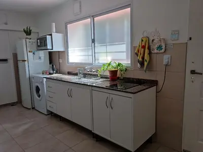 a kitchen with a sink and a refrigerator at AA Departamento Flat Premium Córdoba in Cordoba