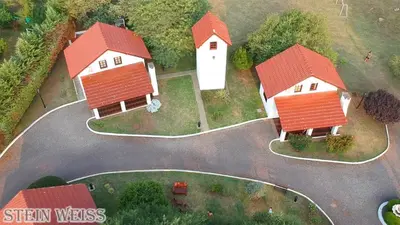 a group of houses with red roofs on a road at Cabañas Stein Weiss in Santa Rosa de Calamuchita
